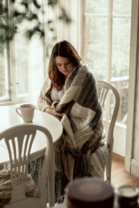 Tess drinking tea with the Stay Awhile Boho Blanket